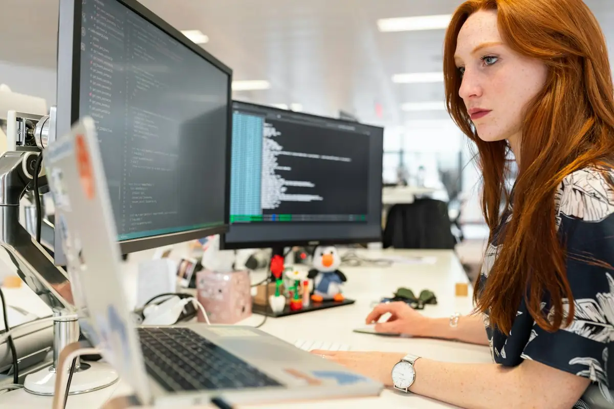 Engineer working at a desk with multiple monitors